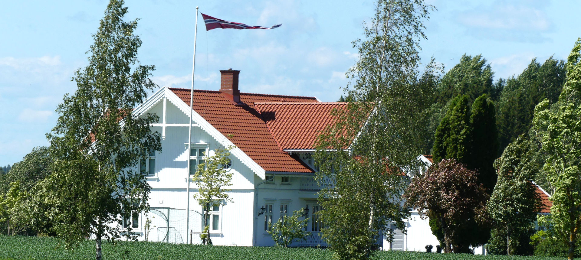 Traditional house with the Norwegian flag flying. | click to enlarge Photo showing Traditional house with the Norwegian flag flying. | click to enlarge